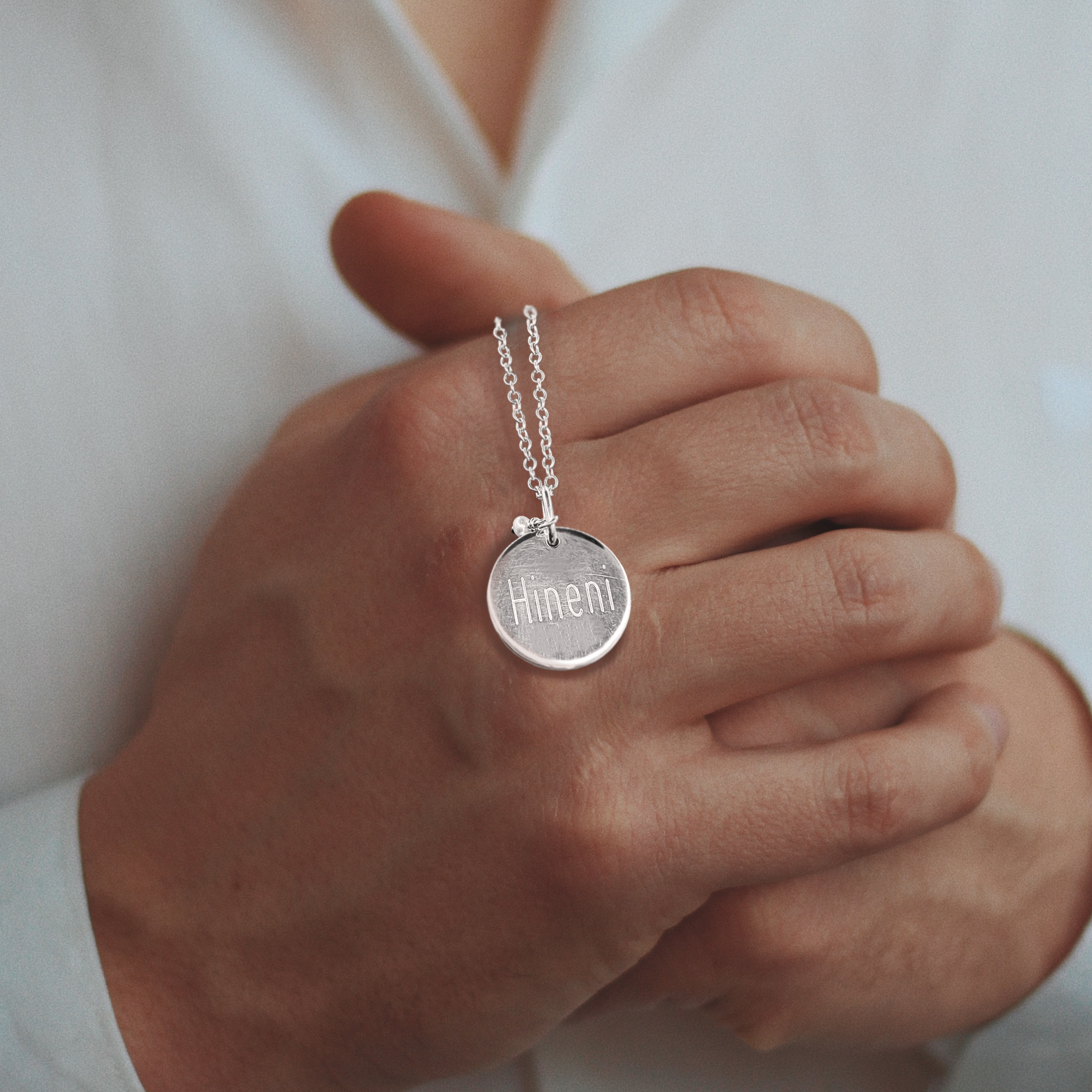 closeup-shot-male-fwearing-white-shirt-holding-silver-men-s-necklace Kopie.png__PID:2f5fc909-fa30-414a-a5e1-c3cd04b2a355